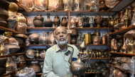 Antique dealer Ahsan Shakeel shows an artefact at his shop selling vintage items in Rawalpindi on October 20, 2026. Photo by Farooq Naeem / AFP
