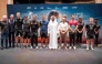 QMMF President Abdulrahman Al-Mannai and QMMF Executive Director Amro Al-Hamad pose for a photo with drivers and riders.
