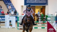 Maryam Abdulkarim Abd guides Jumbo over a fence.