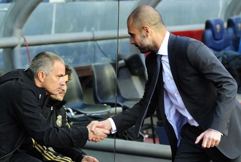 (FILES) This file photo taken on April 21, 2012 shows Real Madrid's Portuguese coach Jose Mourinho (L) shaking hands with Barcelona's coach Josep Guardiola (R) during the Spanish League 