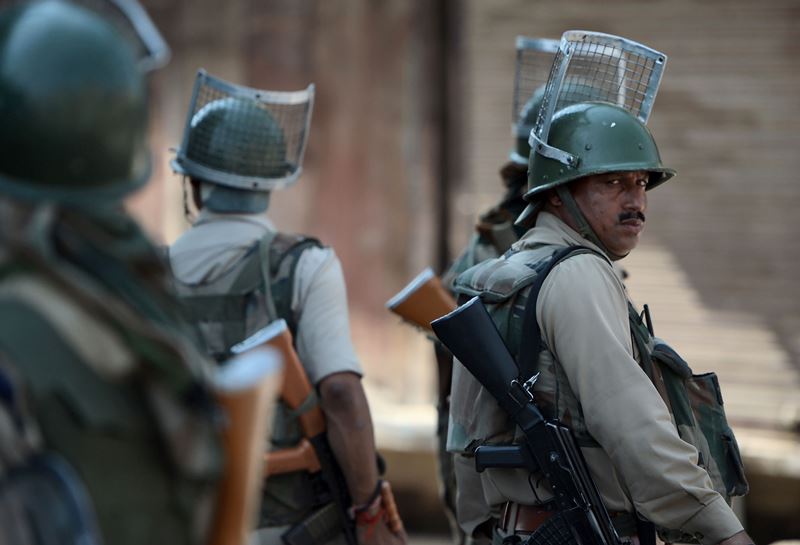Indian paramilitary troopers watch Kashmiri protestors shout pro-freedom and anti-India slogans during a protest against civilian killings in Kashmir's ongoing summer unrest, in Srinagar on September 9, 2016. AFP / TAUSEEF MUSTAFA