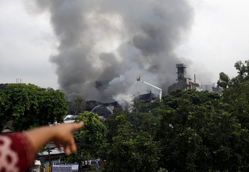  A woman points to a food and cigarette packaging factory on fire outside of Dhaka, Bangladesh, September 10, 2016. REUTERS/Mohammad Ponir Hossain