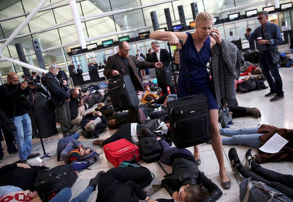 Climate activist group Reclaim the Power lie on the ground and carry luggage during a protest against airport expansion plans at Heathrow Airport in London, Britain October 1, 2016. REUTERS/Neil Hall
