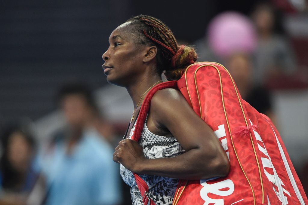 Venus Williams of the US leaves the court after losing to China's Peng Shuai in their women's singles first round match at the China Open tennis tournament in Beijing on October 3, 2016. / AFP / FRED DUFOUR

