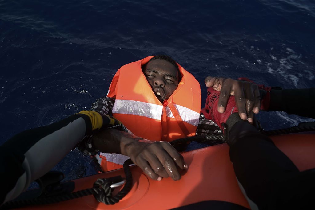 A migrant is rescued by members of Proactiva Open Arms NGO in the Mediterranean Sea, some 12 nautical miles north of Libya, on October 4, 2016. At least 1,800 migrants were rescued off the Libyan coast, the Italian coastguard announced, adding that simila