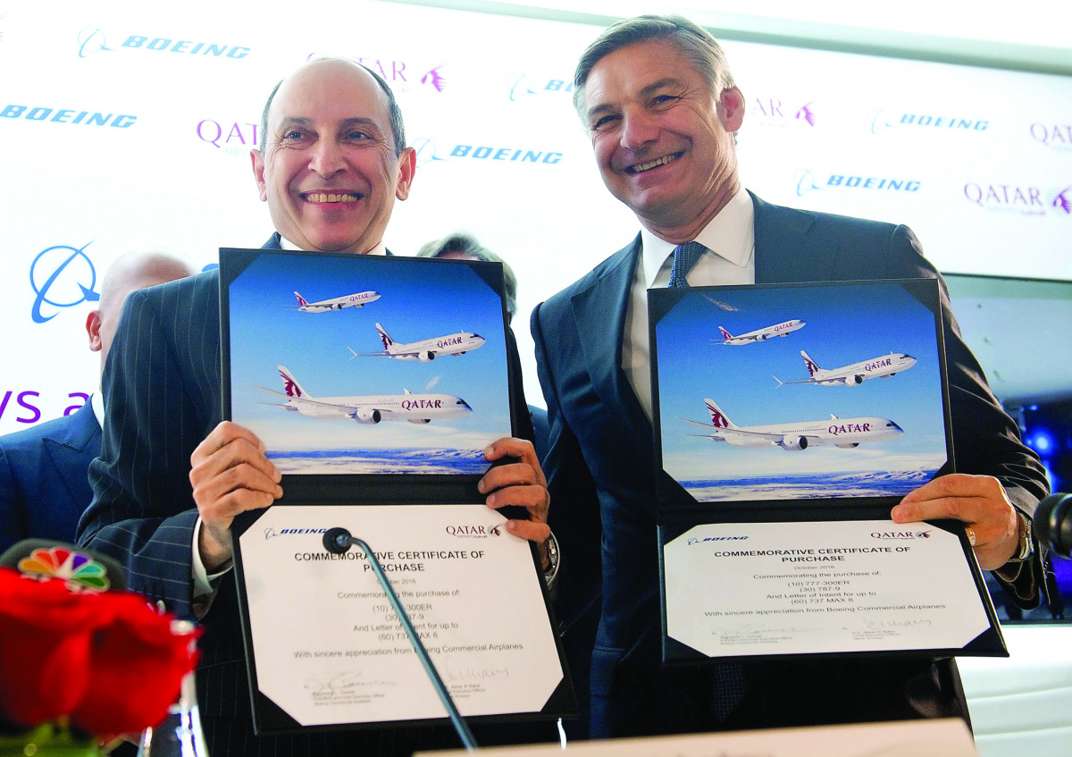 Akbar Al Baker, CEO of Qatar Airways, and Ray Conner, President and CEO of Boeing Commercial Airplanes, hold up commemorative certificates of purchase after announcing a deal for 100 Boeing airplanes, in an order worth $18.6bn, in Washington, yesterday.