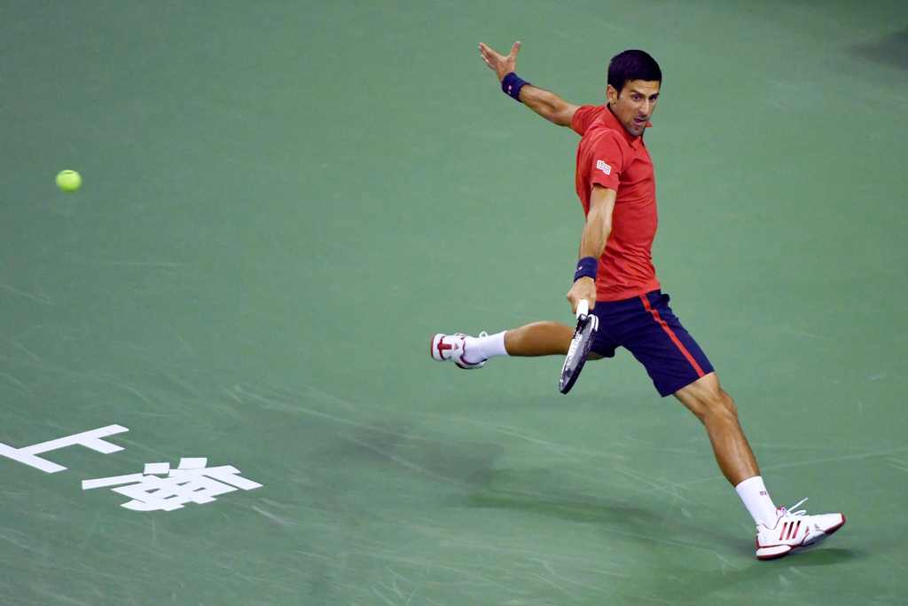 Novak Djokovic of Serbia hits a return against Fabio Fognini of Italy during their men's singles match at the Shanghai Masters tennis tournament in Shanghai on October 11, 2016. / AFP / WANG ZHAO