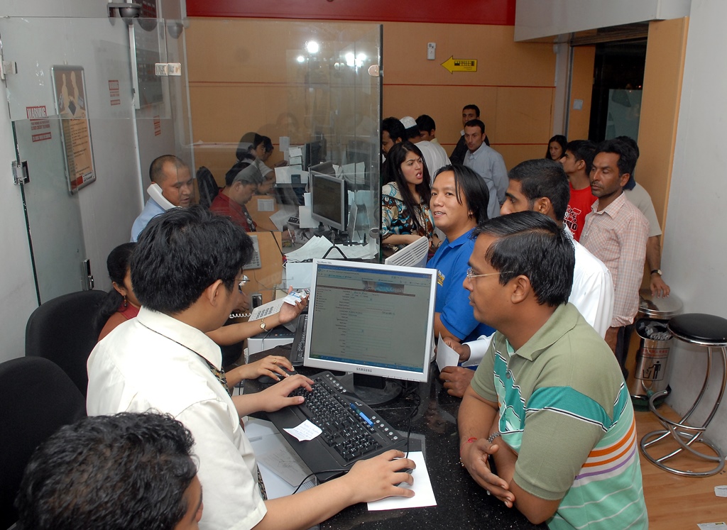 File photo of customers waiting inside a money exchange in Doha.