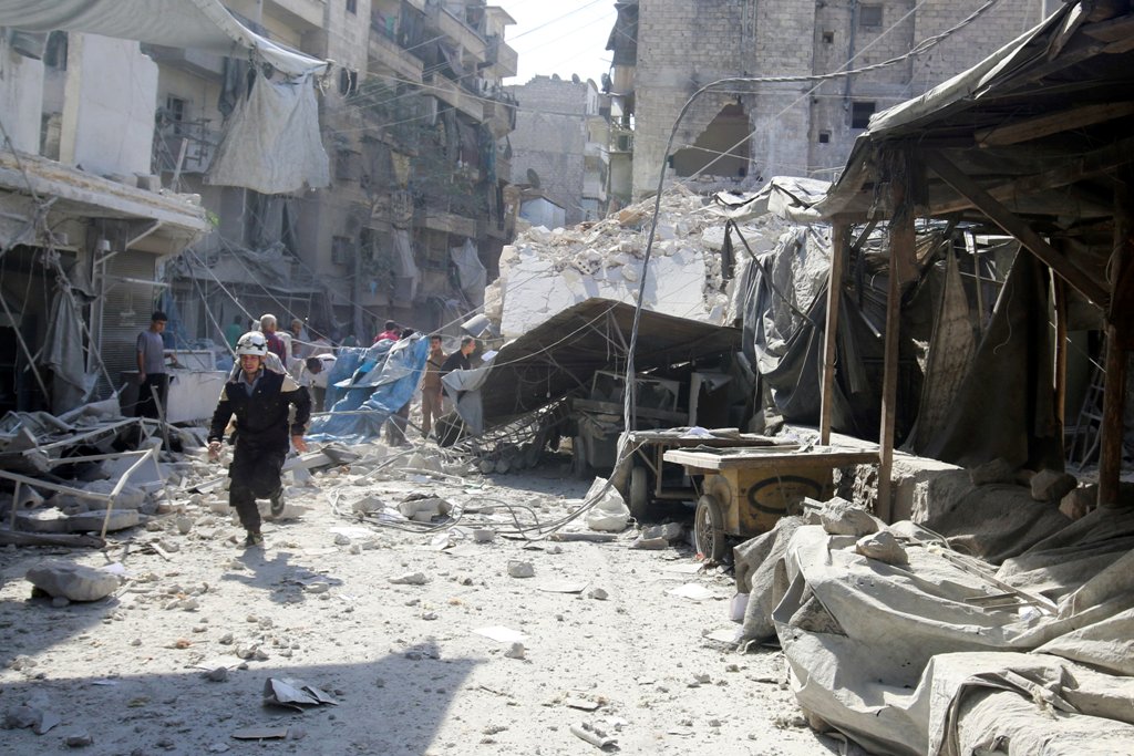 A civil defence member runs at a market hit by air strikes in Aleppo's rebel-held al-Fardous district, Syria October 12, 2016. REUTERS/Abdalrhman Ismail