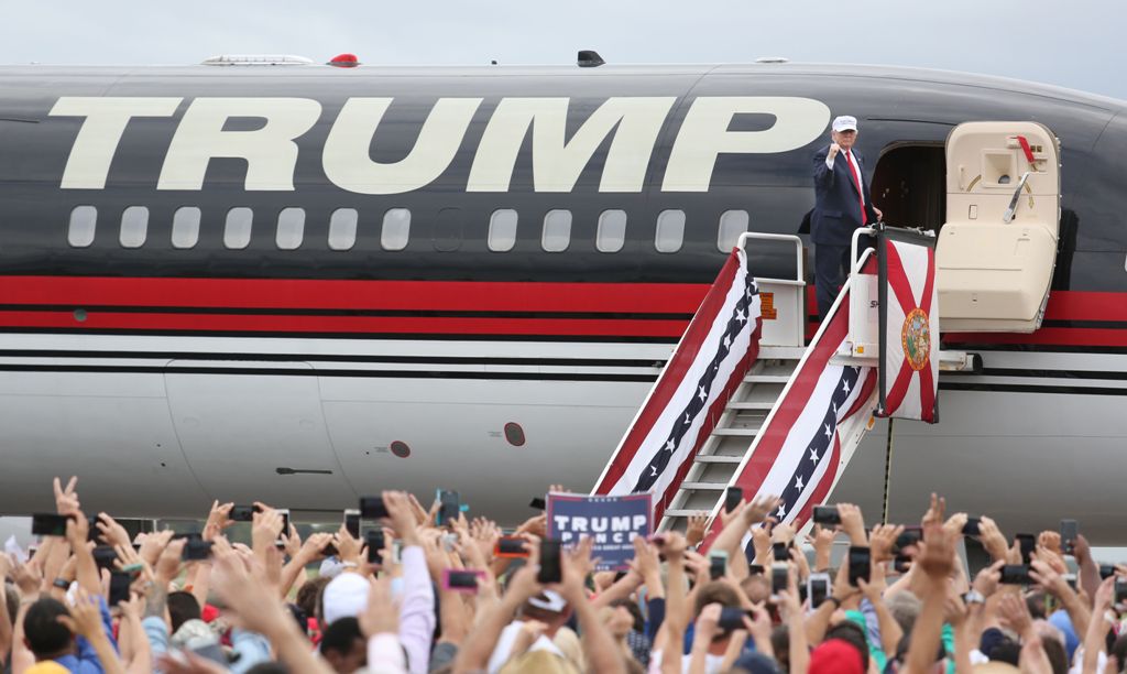 Republican presidential nominee Donald Trump pumps his fist to supporters at the conclusion of his campaign event on the tarmac at Lakeland Linder Regional Airport in Lakeland, Florida on October 12, 2016. / AFP / Gregg Newton
