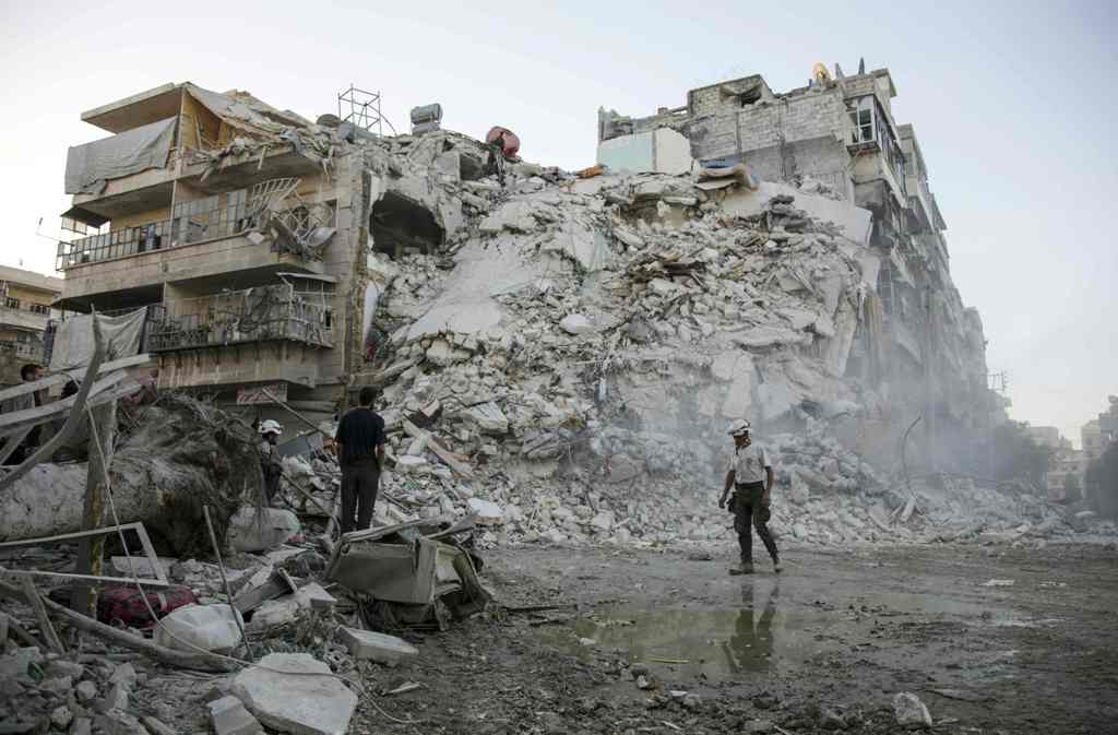 Members of the Syrian Civil Defence, known as the White Helmets, search for victims amid the rubble of a destroyed building following reported air strikes in the rebel-held Qatarji neighbourhood of the northern city of Aleppo, on October 17, 2016.  AFP / 