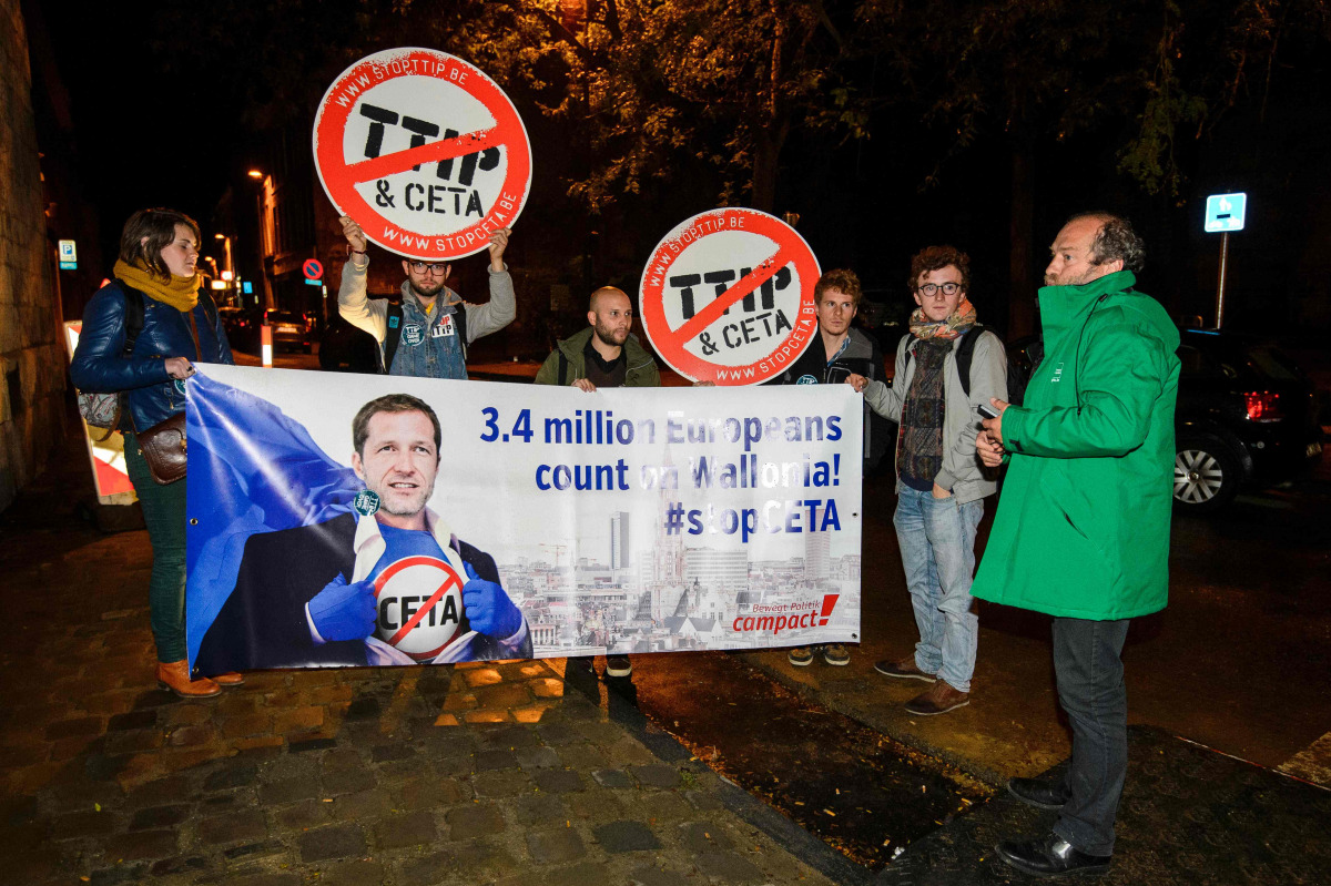 Protesters hold up a placard reading '3,4 million Europeans count on Wallonia - stop CETA' as a meeting on CETA (EU-Canada Comprehensive Economic and Trade Agreement) takes place at the Walloon parliament in Namur, Belgium, on October 18, 2016. The Europe