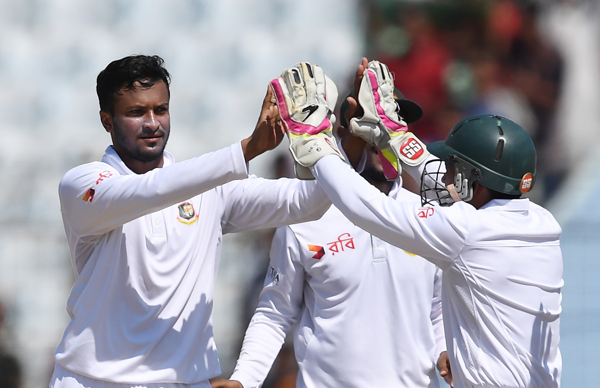 Bangladesh' Shakib Al Hasan (L) with captain Mushfiqur Rahim celebrates the wicket of England's Ben Duckett during the third day of the first Test match between Bangladesh and England at Zahur Ahmed Chowdhury Cricket Stadium in Chittagong on October 22, 2