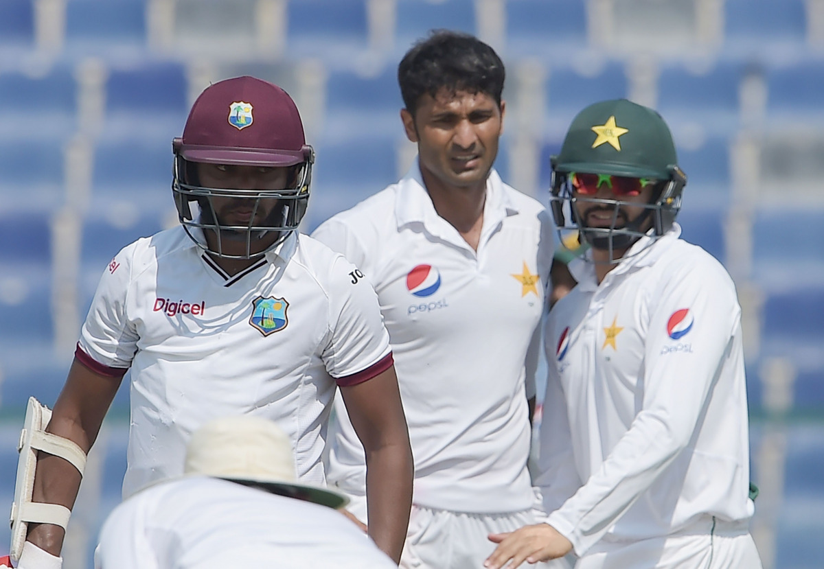 West Indies' batsman Devendra Bishoo (L) leaves the ground after his dismissal by Pakistani bowler Sohail Khan (C) on the third day of the second Test between Pakistan and the West Indies at the Sheikh Zayed Cricket Stadium in Abu Dhabi on October 23, 201