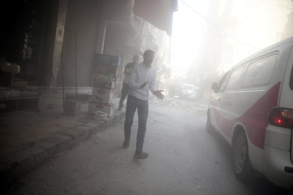 Men walk amidst dust after shelling in the rebel held besieged town of Douma, eastern Ghouta in Damascus, Syria October 20, 2016. REUTERS/Bassam Khabieh
