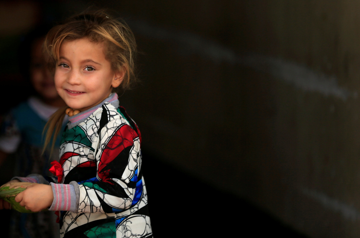 A displaced girl who recently fled the Islamic State's stronghold on the outskirts of Mosul waits to be transferred to a tent, at Debaga camp on the outskirts of Erbil, Iraq October 23, 2016. (REUTERS/Thaier Al-Sudaini)