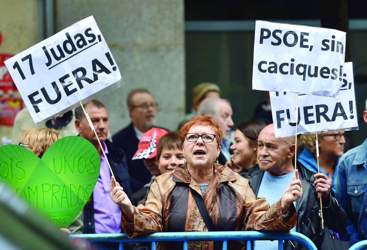 A PSOE supporter holds placards reading 