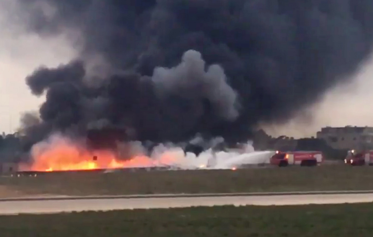 Still image taken from video shows fire trucks aiming their hoses at the burning wreckage of a small plane which crashed at the edge of the runway at the airport in Valletta, Malta, 24 October 2016. (REUTERS/Ed De Gaetano via Reuters)