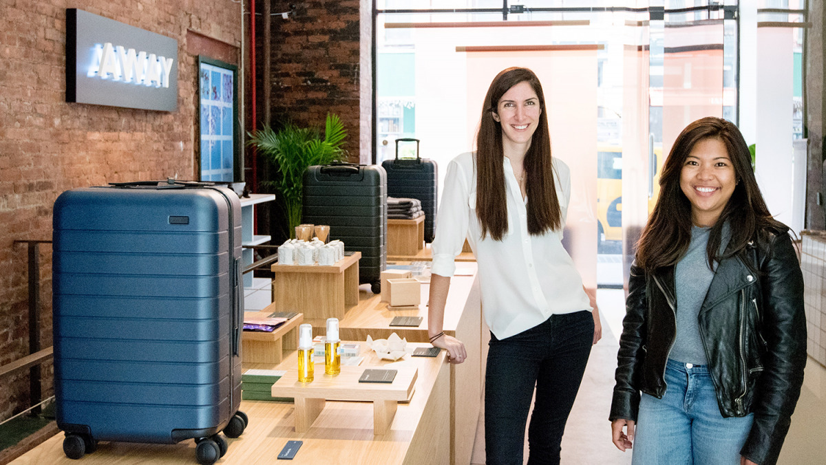 The founders with the suitcase inside their shop
