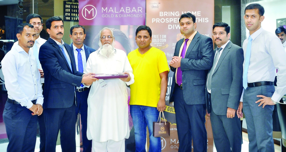 Sayed Musharaf Ali Haroon, winner of the ‘Delightful Diwali’ campaign by Malabar Gold & Diamonds receives 500 gold coins from Santhosh T V — Regional Head, in the presence of officials from Malabar Gold & Diamonds.