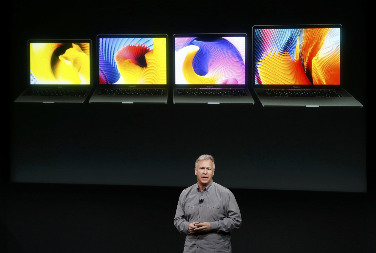 Phil Schiller, senior vice president of worldwide marketing at Apple, speaks under a graphic of the new MacBook Pro laptop computers during an Apple media event in Cupertino, California, U.S. October 27, 2016. (REUTERS/Beck Diefenbach)