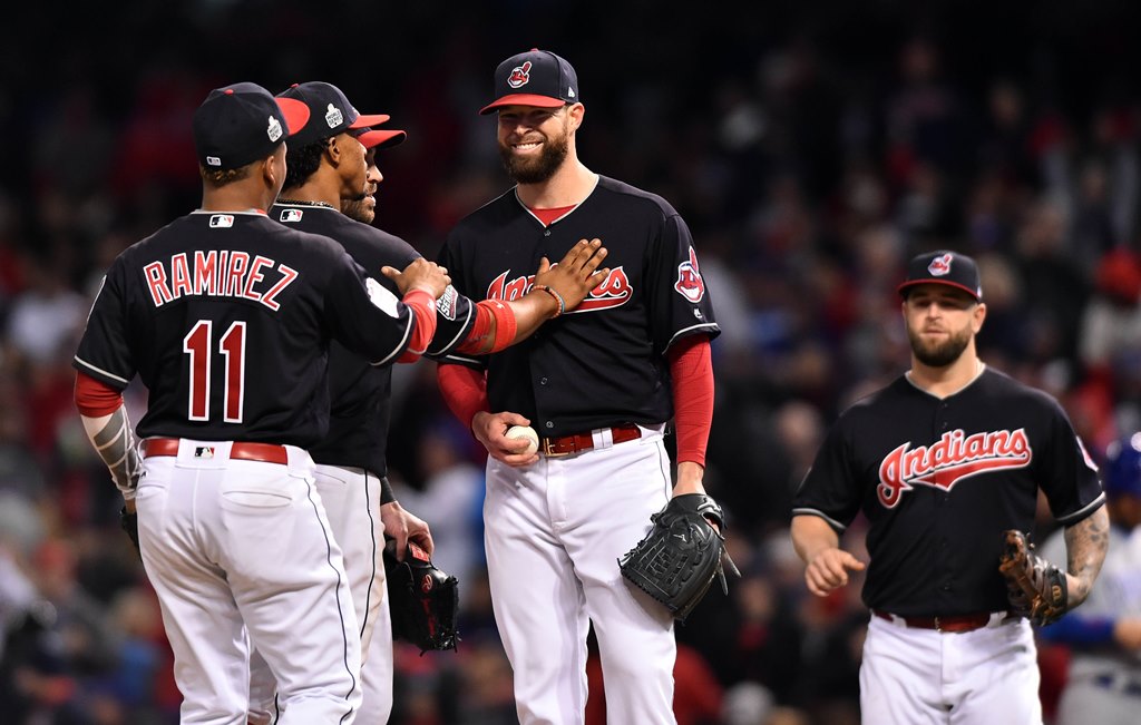 Cleveland Indians starting pitcher Corey Kluber (middle) is congratulated by teammates as he waits to be relieved in the 7th inning against the Chicago Cubs in game one of the 2016 World Series at Progressive Field. Ken Blaze-USA TODAY Sports
