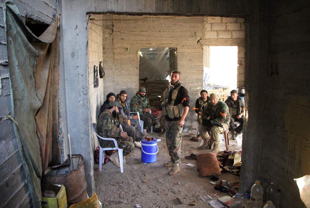 Rebel fighters from the Jaish al-Fatah (or Army of Conquest) brigades have a tea in a building under construction on October 29, 2016 in the neighbourhood of Dahiyet al-Assad, southwest of Aleppo, after they retook control of the area./ AFP / Omar haj kad
