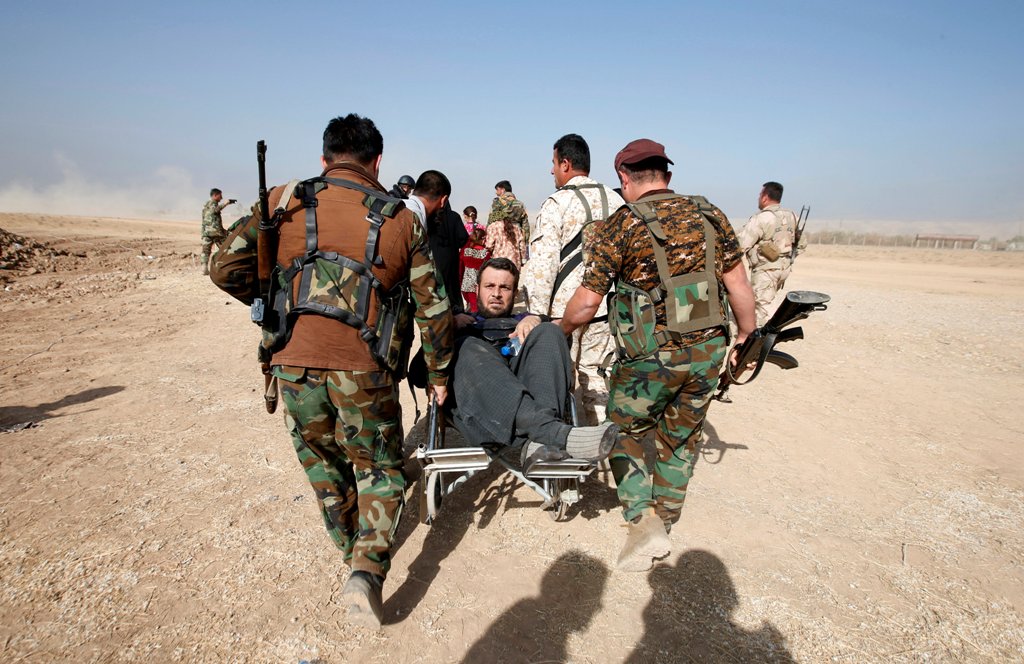 Kurdish Peshmerga fighters carry a wheelchair-bound man, Abbas Ali, 42, after he escaped with his wife and four children from the Islamic State-controlled village of Abu Jarboa, Iraq October 31, 2016. REUTERS/Azad Lashkari TPX IMAGES OF THE DAY
