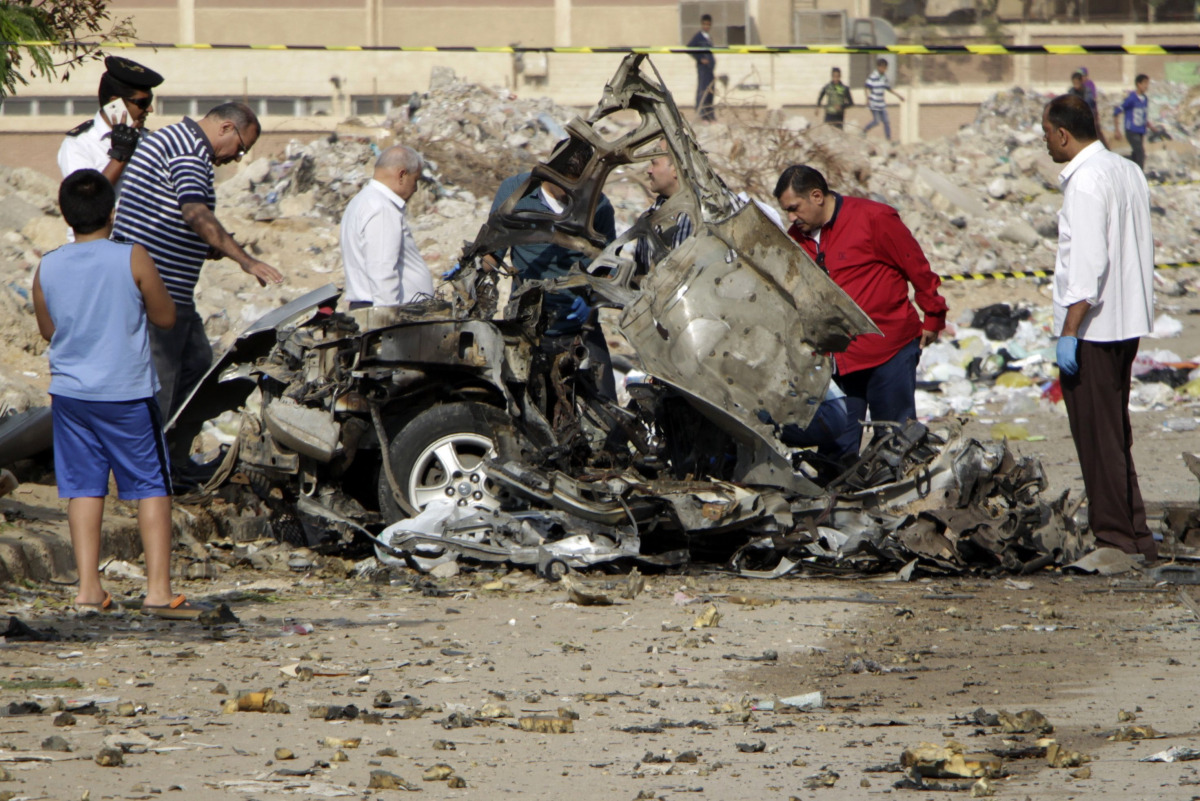 Egyptian policemen inspect the wreckage of a car after a bomb exploded in the eastern Nasr City district of the Egyptian capital Cairo on November 4, 2016. An Egyptian judge in one of the trials of ousted Islamist president Mohamed Morsi escaped unharmed 