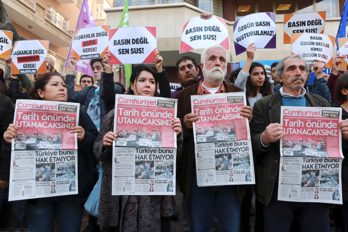 Protesters hold copies of the latest edition of the Turkish daily newspaper 