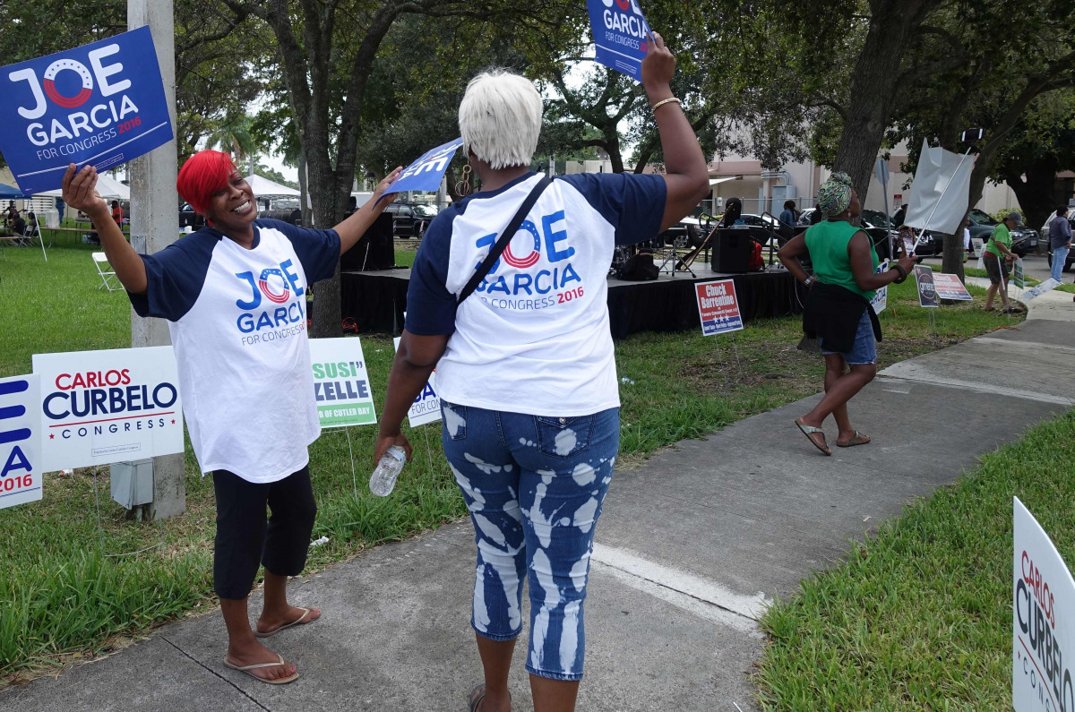 People confer during an event called 'Souls to the Polls' on November 6, 2016 in Cutler Bay, Florida, which aims to encourage minority voter turnout in the key swing state of Florida. Experts say black and Hispanic turnout is surging as many hope to keep 