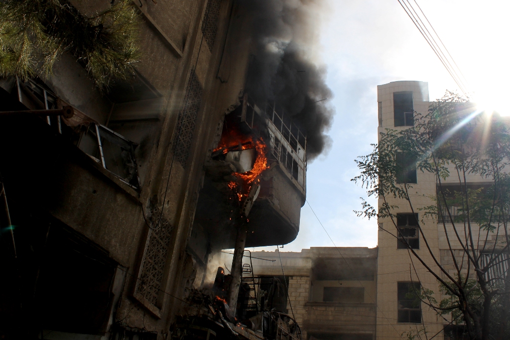 Flame and smoke rises from a building after the war crafts belonging to the Russian Army and Syrian regime carried an airstrike over residential areas in Duma district of Damascus on November 7, 2016. ( Amaar Doumani - Anadolu Agency )
