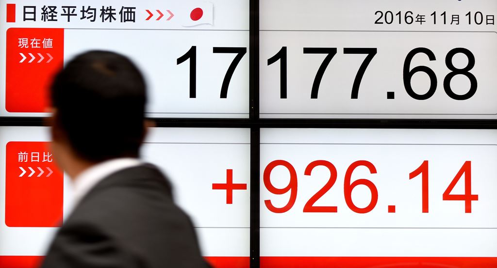 A businessman looks at an electric quotation board flashing the Nikkei key index of the Tokyo Stock Exchange (TSE) in front of a securities company in Tokyo on November 10, 2016. AFP / TORU YAMANAKA
