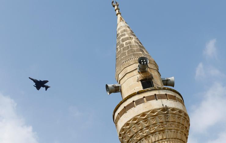 A Turkish Air Force F-16 fighter flies over a minaret after it took off from Incirlik air base in Adana, Turkey. Reuters/File Photo
