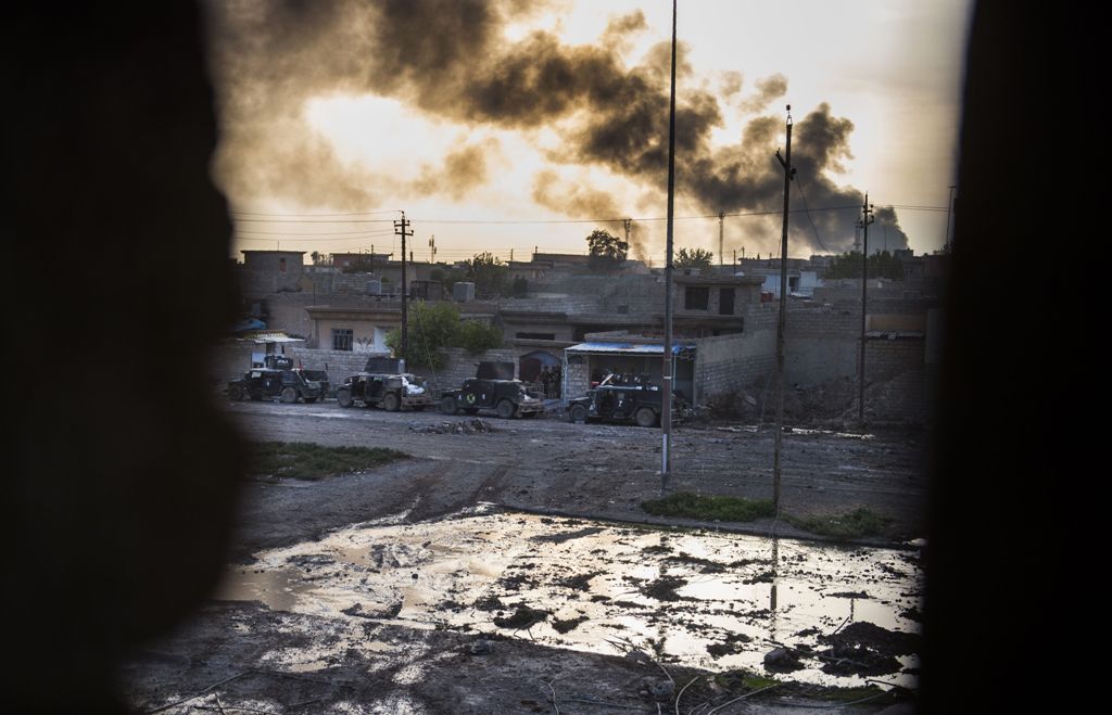 Smoke billows from Islamic State positions as a convoy from the Iraqi Special Forces 2nd division move into position during fighting in the eastern Samah area of Mosul on November 11, 2016. Elite Iraqi troops battled the Islamic State group in the streets