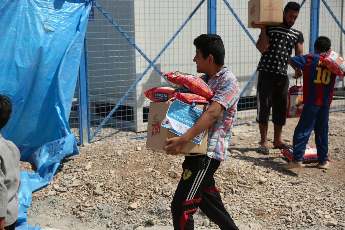 Beneficiaries carrying food items at a distribution centre in Mosul.
