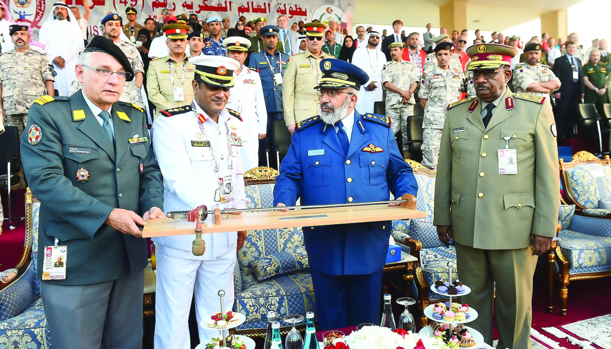 Colonel Bruno Wolfensberger (left), President CISM Sport Committee Shooting receiving a memento from Lieutenant-General (Pilot) Ghanem bin Shaheen Al Ghanem (second right) in the presence of Major General Dahlan Al Hamad (right), the President of the Qata