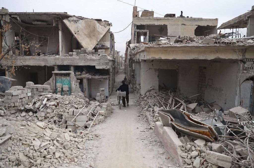  A Syrian man walks between destroyed buildings in the rebel-held town of Douma on the eastern outskirts of the capital Damascus on November 13, 2016. Douma, the largest town in the Eastern Ghouta area with more than 100,000 residents, is surrounded and r