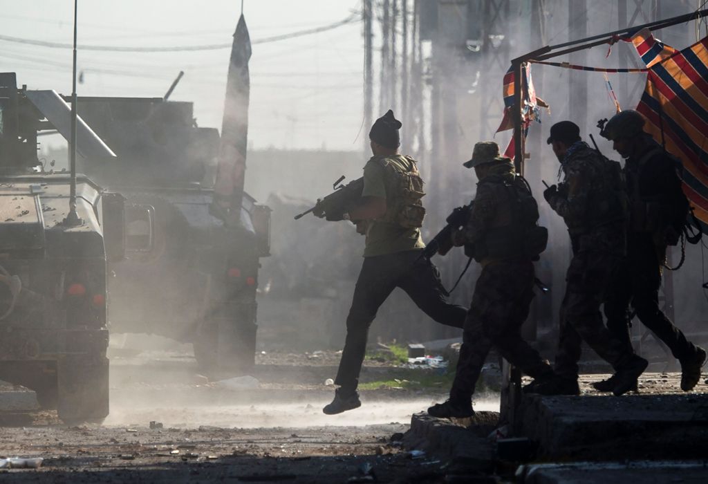 Iraqi Special Forces 2nd division soldiers come under fire from Islamic State (IS) group fighters while running across an intersection as they try to push forward in the Karkukli neighbourhood of Mosul on November 13, 2016.   AFP / Odd ANDERSEN