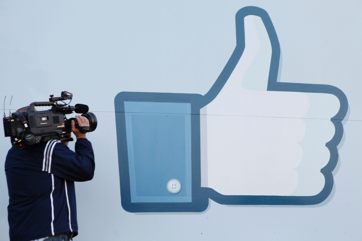 A videographer shooting the side of Facebook Like Button logo displayed at the entrance of the Facebook Headquarters in Menlo Park, California, May 18, 2012.  (AFP) 