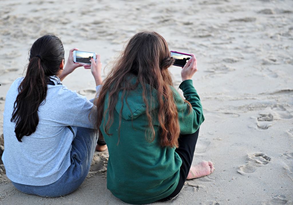 This file photo taken on November 27, 2015 shows women look at their cell phones at the Assateague Island National Seashore near Berlin, Maryland. AFP / KAREN BLEIER