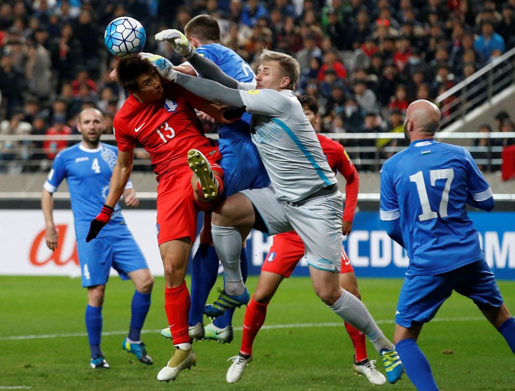 Koo Jae-cheol of South Korea in action with Egor Krimets and Aleksandr Lobanov of Uzbekistan. REUTERS/Kim Kyung-Hoon