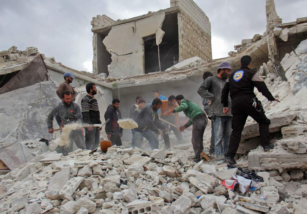 Rescuers and civilians inspect a destroyed building in the Syrian village of Kfar Jales, on the outskirts of Idlib, following air strikes by Syrian and Russian warplanes on November 16, 2016.  AFP / Omar haj kadour