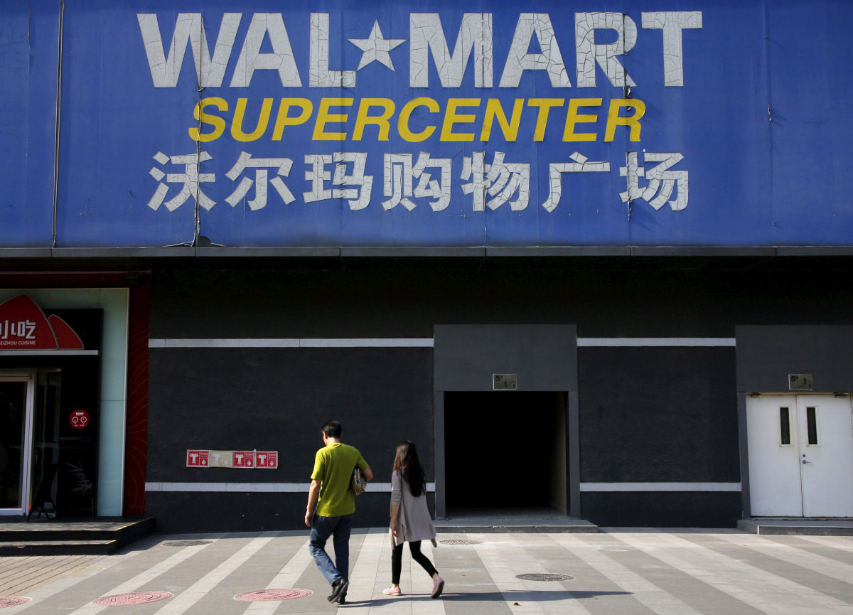 Pedestrians walk past a signboard of Wal-Mart at its branch store in Beijing, October 15, 2015 (REUTERS / Kim Kyung-Hoon) 