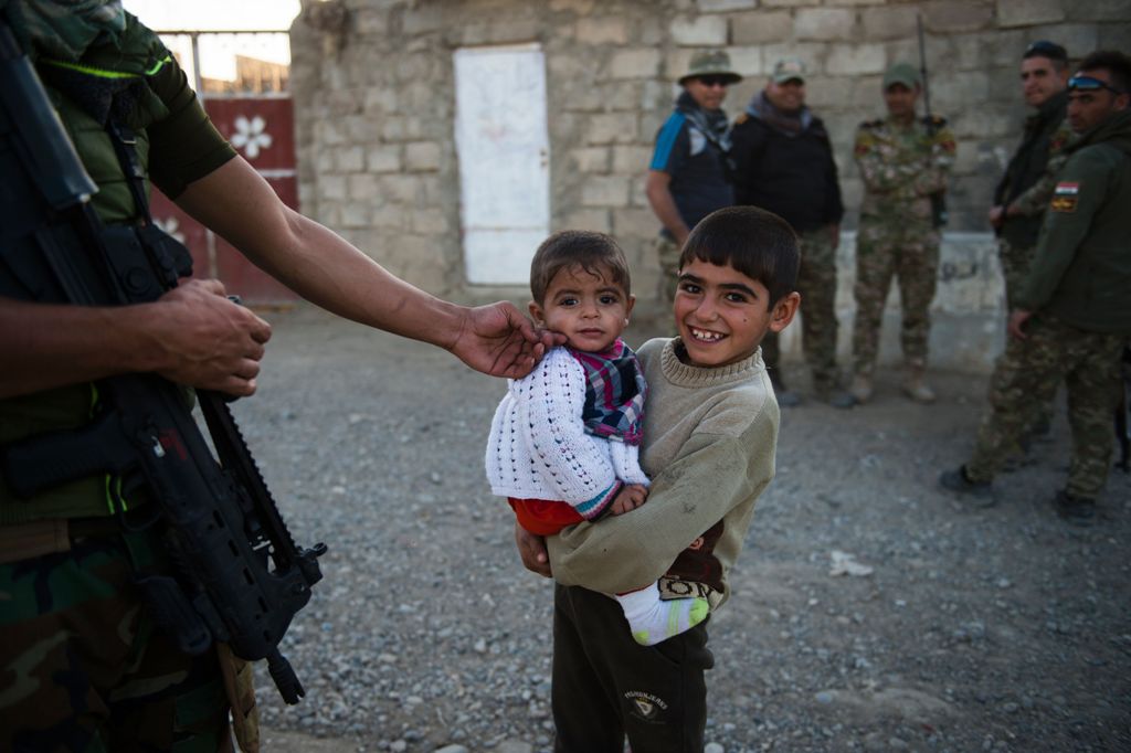 Members of forces from Iraq's elite Rapid Response Division engage with locals on November 19, 2016 as they patrol in the village of Tall Adh-Dhahab, located some 10 kilometres (6 miles) south of Mosul. AFP / Odd ANDERSEN
