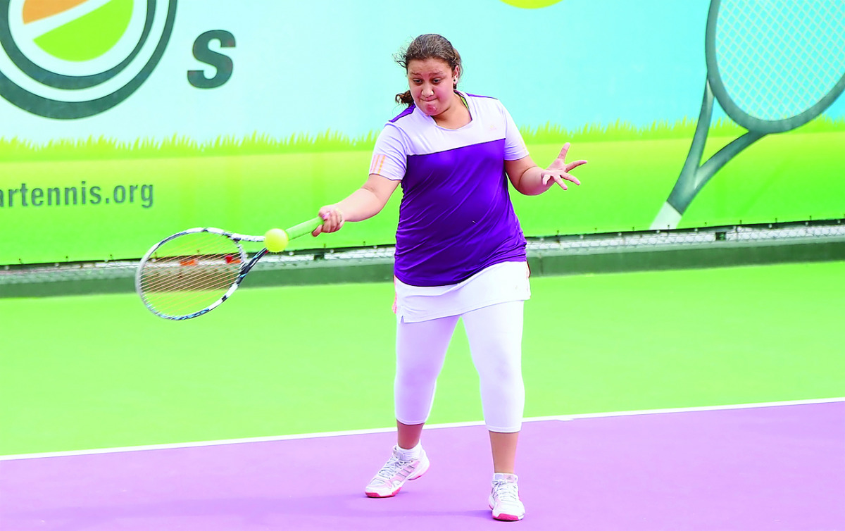 A junior tennis player in action during the 2016 Qatar ExxonMobil Junior Open Tennis Tournament at the Khalifa Tennis and Squash Complex.