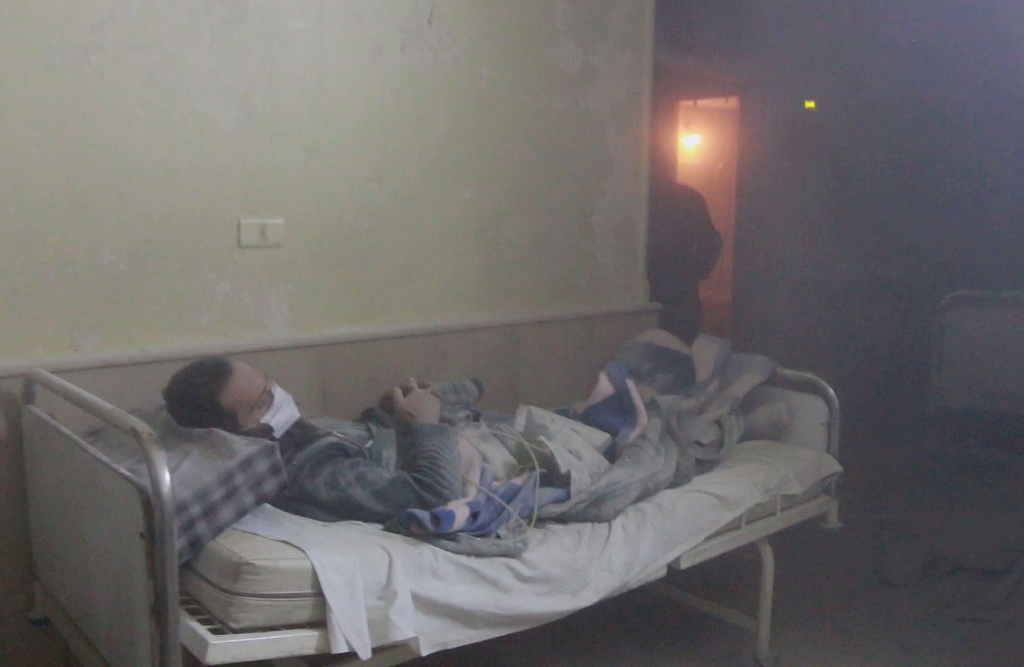 This photo captured from a video shows that a wounded Syrian man lies on his bed at Omar Bin Abdul Aziz Hospital in Maadi district of Aleppo as the patients are being evacuated on November 21, 2016, after the hospital was targeted by the air strikes two d