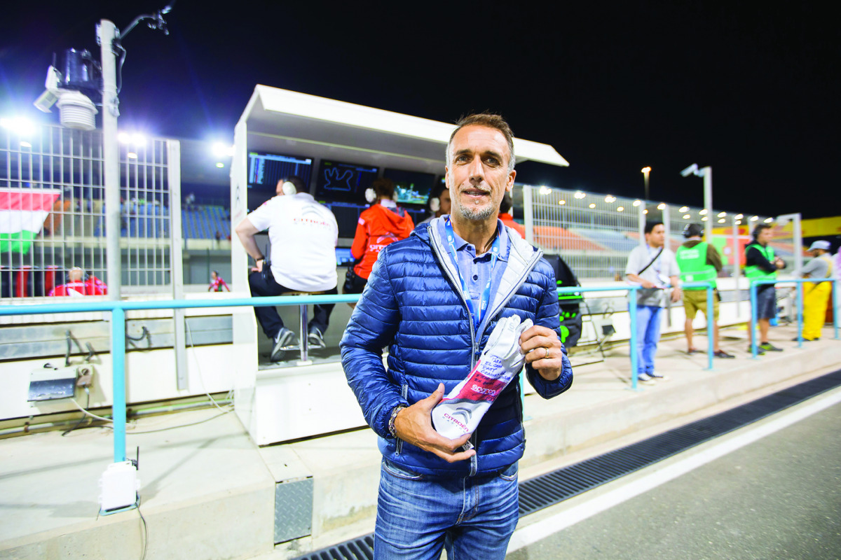 Argentinean football legend Gabriel Omar Batistuta, nicknamed Batigol, poses for a photo with a glove, signed by FIA World Touring Car Champion Jose Maria Lopez, during the WTCC DHL Race of Qatar at the Losail International Circuit on Friday. Batistuta pl