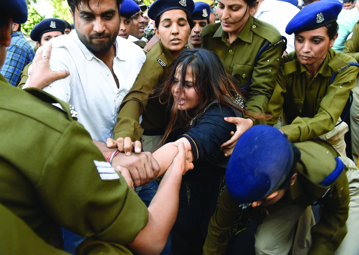 Indian police personnel detain an activist from the Congress Party student wing during a protest against demonetisation in New Delhi on November 28, 2016. Tens of thousands of people turned out November 28 for nationwide protests against India's controver