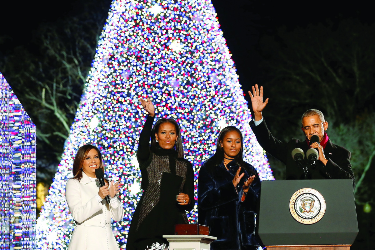 President Barack Obama (right), joined by First Lady Michelle Obama (second left), their daughter Sasha (second right) and celebrity Eva Longoria, react after pressing a button to light the National Christmas Tree in Washington, yesterday.